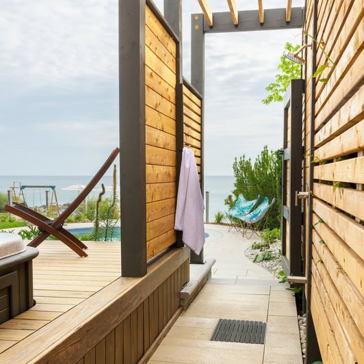 Losas de patio Travertina Raw de Techo-Bloc utilizadas como piso en un diseño de ducha exterior. 