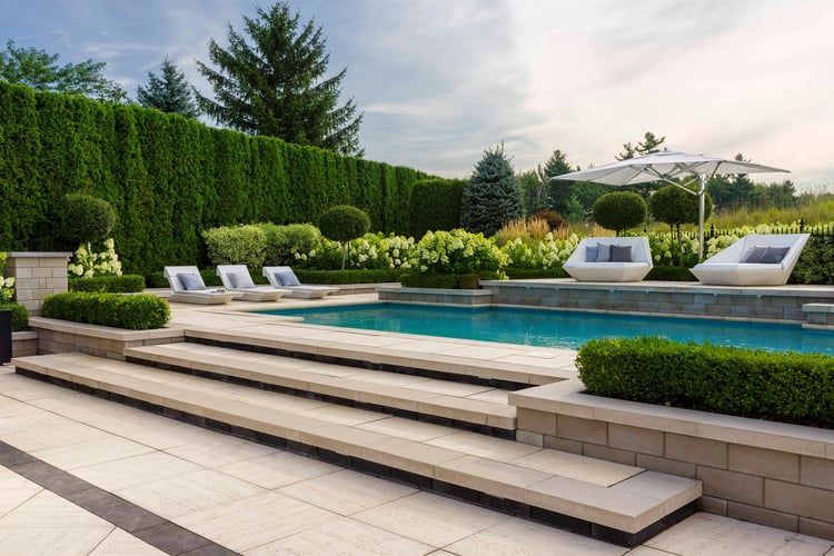 Pooldeck con losas Travertina Raw Raw y sillas 