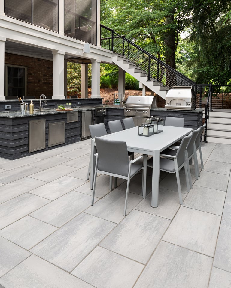 Patio trasero con losas Blu Grande Smooth y una cocina exterior