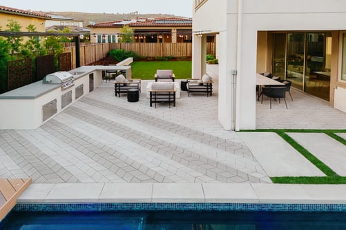 Impresionante y moderna cocina al aire libre junto a una piscina con comedor y sala de estar al aire libre. Perfecto para familias. Todo diseñado con productos Techo-Bloc.