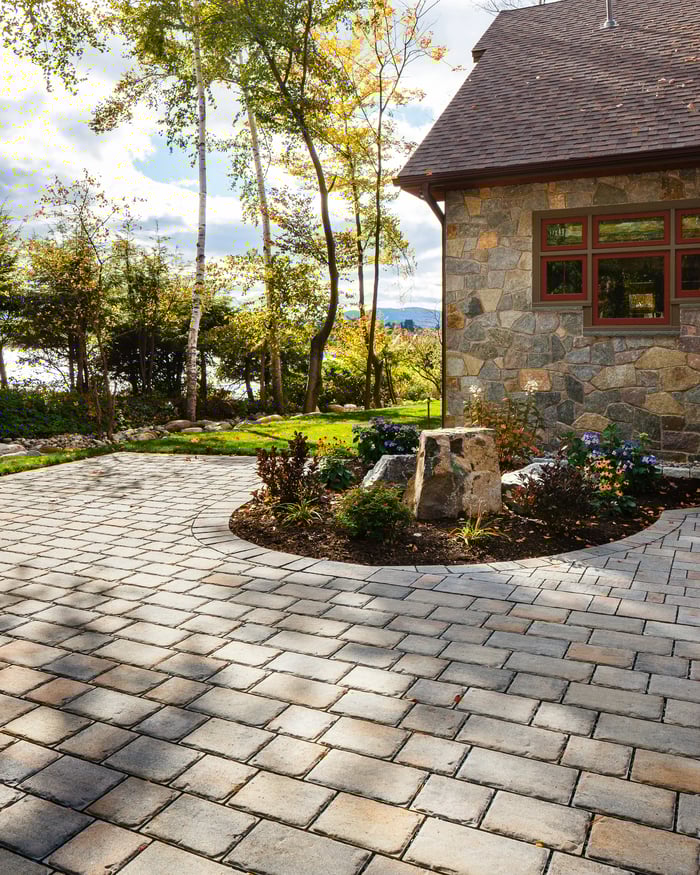 Patio lateral con un jardín y adoquines Pure