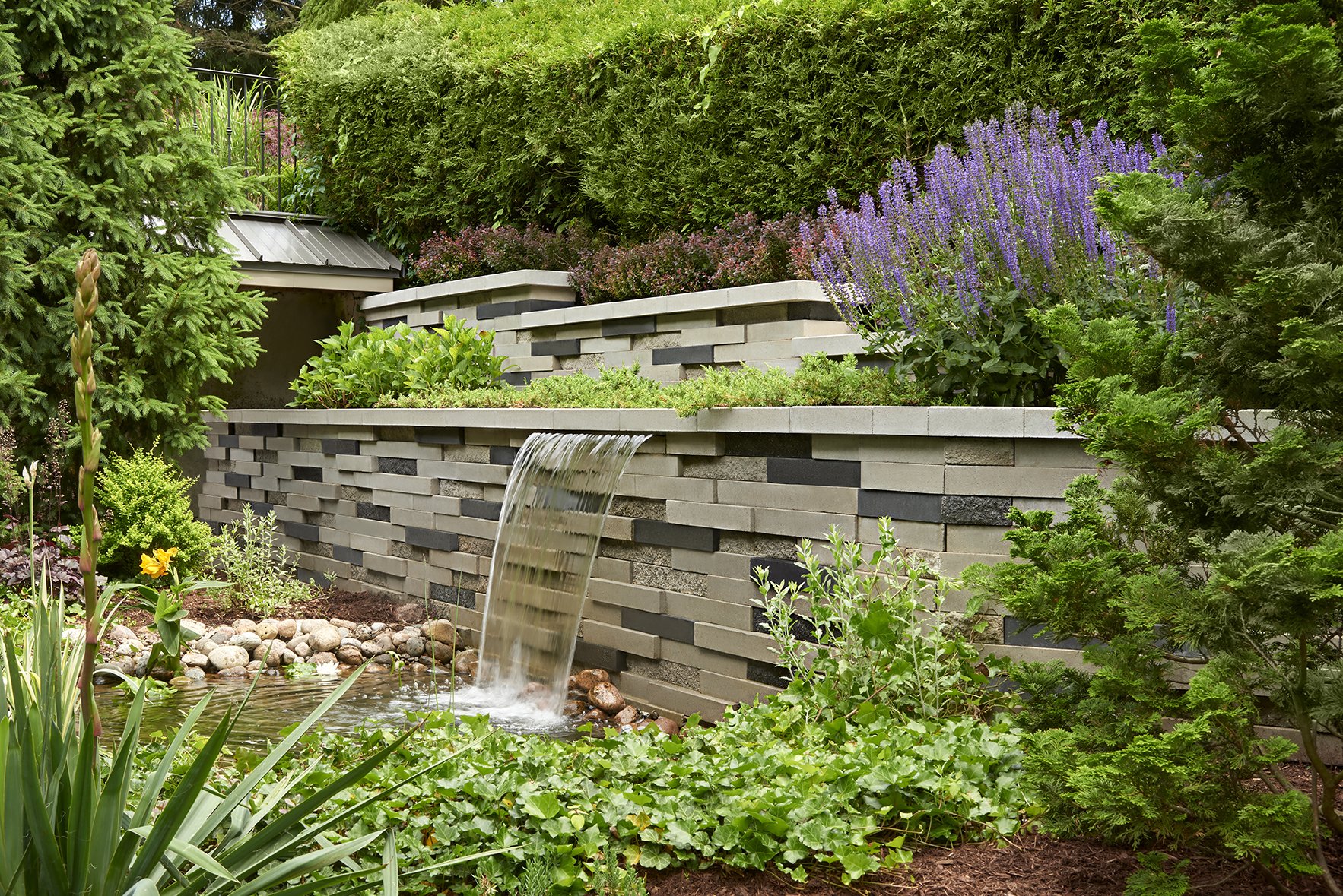 Cascada de jardín construida con nuestro muro de contención Graphix. 
