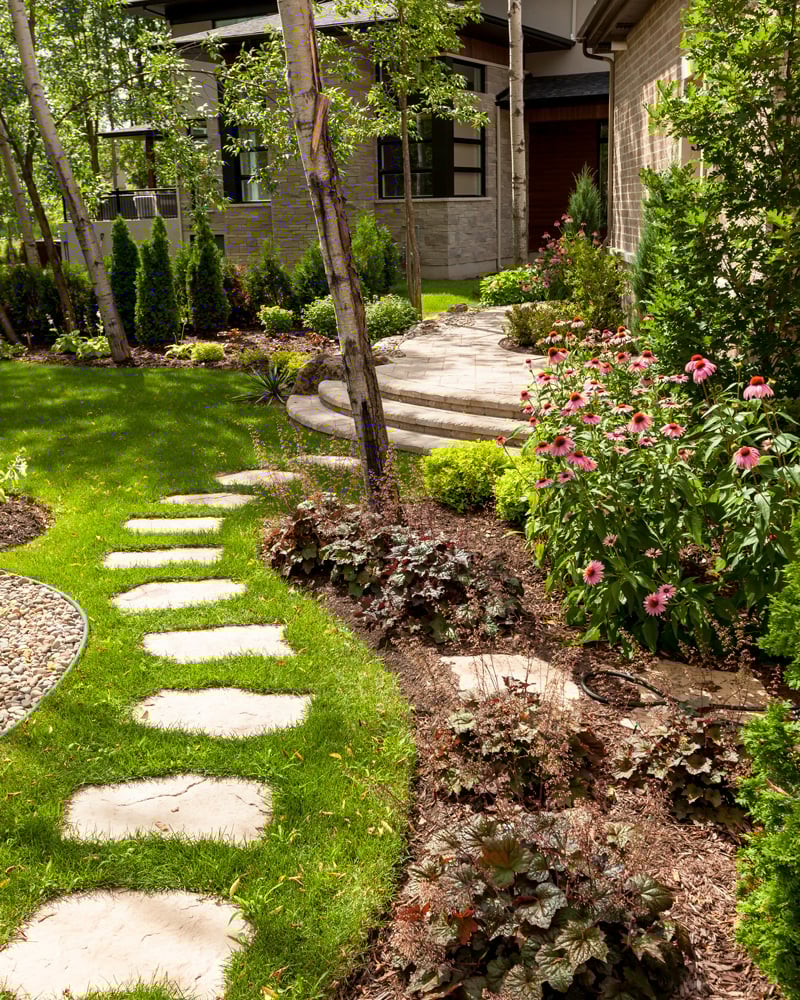 Camino de jardín trasero que conduce al patio diseñado con nuestras piedras de concreto Maya. 