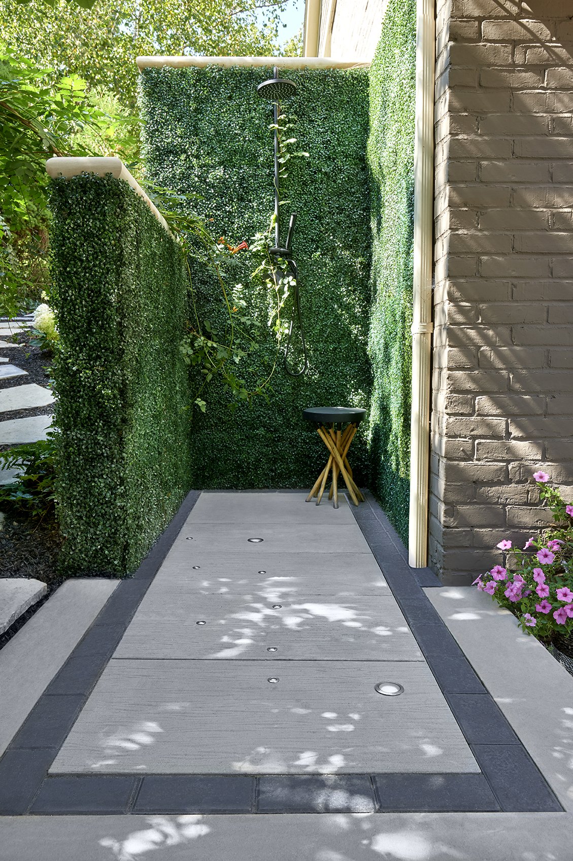 Ducha exterior con losas Ocean Grande y muchas plantas 
